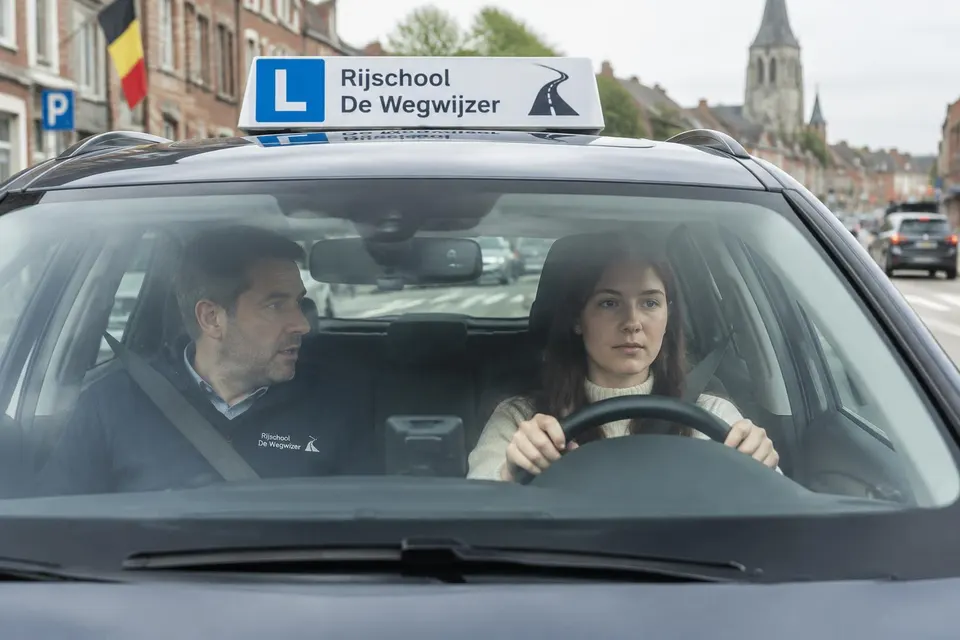 Illustratief beeld van een rijinstructeur met een leerling in een lesauto